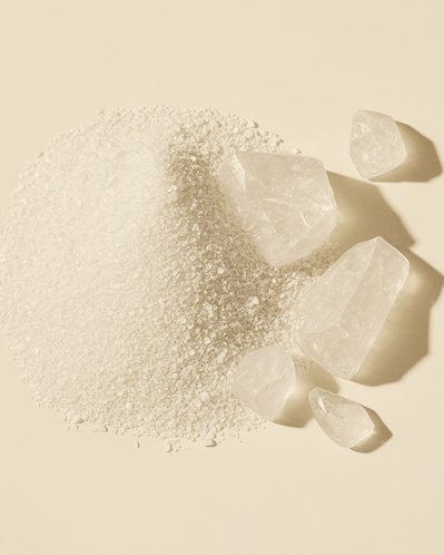 Ectoin shown as a mound of fine white crystalline powder on a cream surface